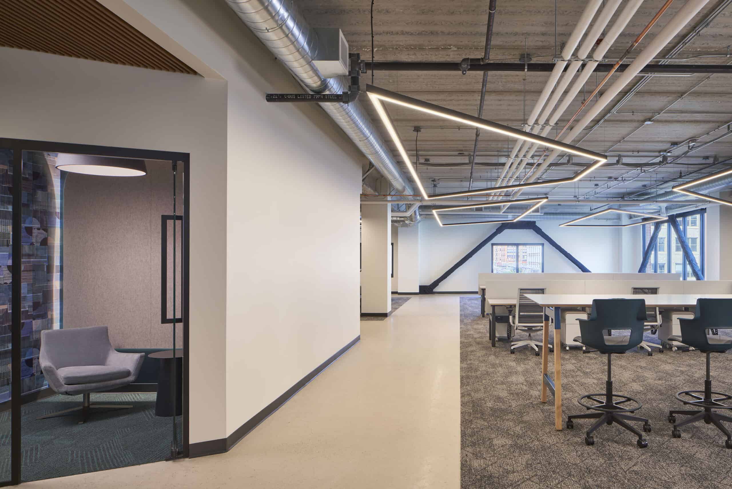 An open office area and walkway with modern, fun lighting. 